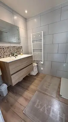 a bathroom with a sink and a large mirror at Location maison vacances T3 in Gruissan