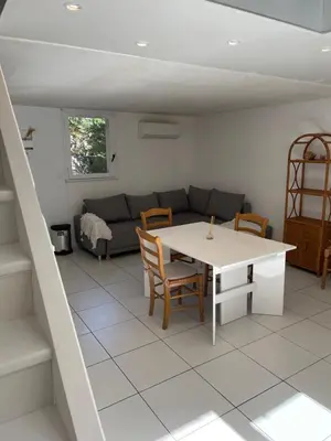 a living room with a table and a couch at Location maison vacances T3 in Gruissan