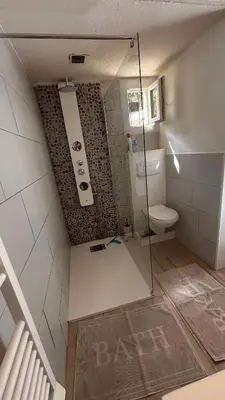 a bathroom with a toilet and a glass shower at Location maison vacances T3 in Gruissan