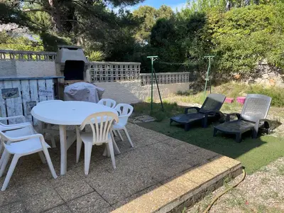 a group of chairs and a table and a grill at Location maison vacances T3 in Gruissan
