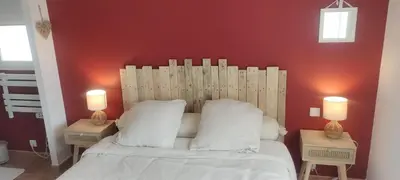 a bedroom with a white bed with two lamps at Gîte Le Bellevue in Montels