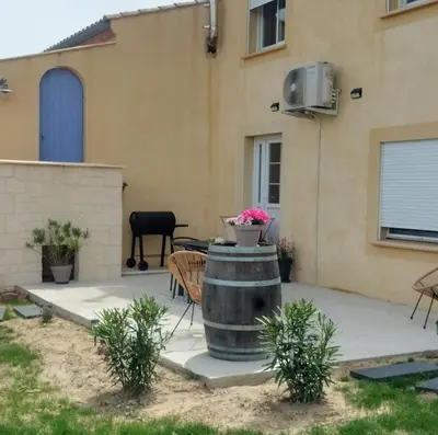 a patio with a barrel in front of a house at Gîte Le Bellevue in Montels