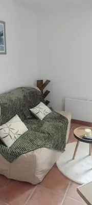 a couch with pillows on it in a living room at Gîte Le Bellevue in Montels