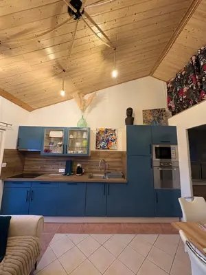a kitchen with blue cabinets and a wooden ceiling at Gîte de Mia in Ventenac en Minervois