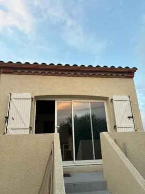 a house with white doors and a fence at Gîte de Mia in Ventenac en Minervois