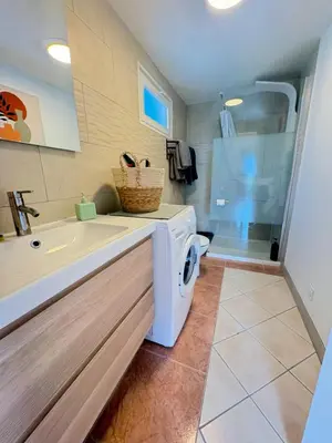 a bathroom with a washing machine and a shower at Gîte de Mia in Ventenac en Minervois