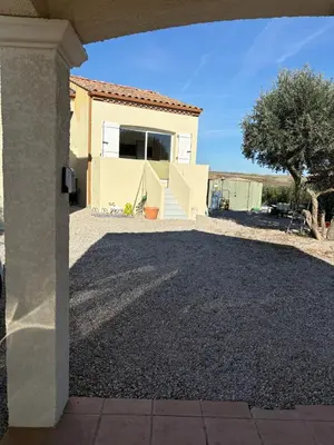 a house with a gravel driveway with a garage at Gîte de Mia in Ventenac en Minervois