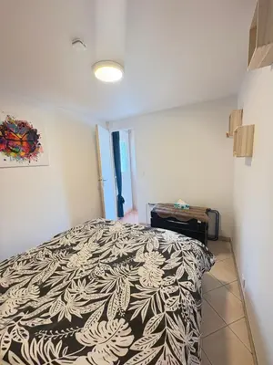 a bedroom with a bed with a black and white comforter at Gîte de Mia in Ventenac en Minervois