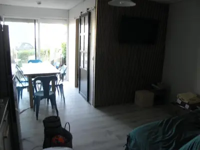 a bedroom with a table and a dining room with a table and chairs at Appart RDC avec cour à 60 m plage du Grazel Gruissan in Gruissan