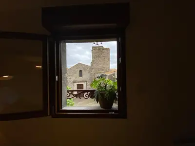 a window with a view of a stone building at La Nine in Aigne