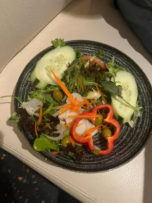 a plate of salad with vegetables on a table at La Nine in Aigne