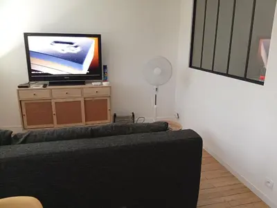 a living room with a couch and a flat screen tv at Mistral gagnant ! T1 calme avec vue, parking, télétravail, Wi-Fi, proche CV et gare in Mazamet