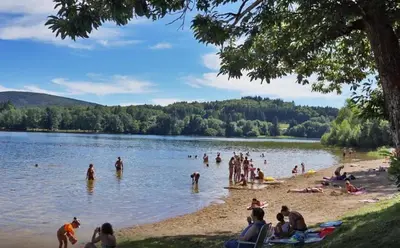 a group of people on a beach in a lake at Mistral gagnant ! T1 calme avec vue, parking, télétravail, Wi-Fi, proche CV et gare in Mazamet
