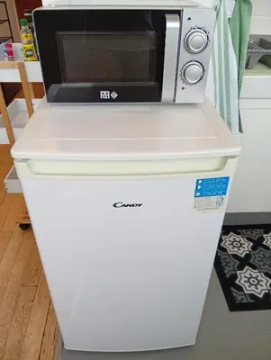 a microwave sitting on top of a white refrigerator at Mistral gagnant ! T1 calme avec vue, parking, télétravail, Wi-Fi, proche CV et gare in Mazamet