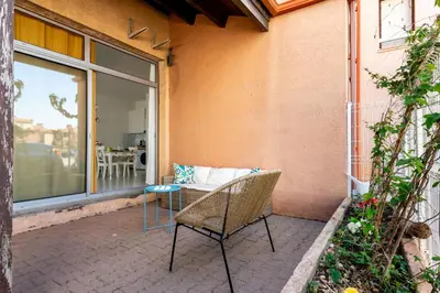 a patio with a table and a chair and a window at Appartement rez-de-chaussée Plage du Grazel in Gruissan