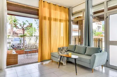 a living room with a couch and a table at Appartement rez-de-chaussée Plage du Grazel in Gruissan
