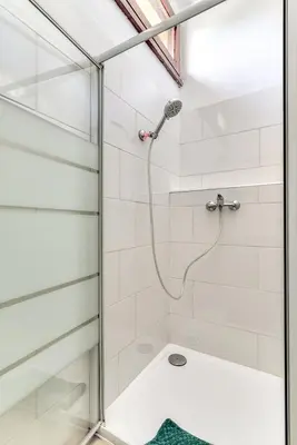a shower with a glass door in a bathroom at Appartement rez-de-chaussée Plage du Grazel in Gruissan