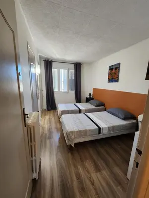 two beds in a room with wooden floors at Grand appartement vue sur la Cité ! in Carcassonne