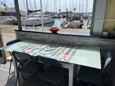 a table with a sign on top of a marina at Gruissan Plage Studio RDC avec Piscine Wifi Parking Clim in Gruissan