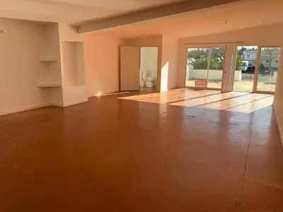 an empty living room with a wooden floor and sliding glass doors at Local, Training room, seminars, meetings, courses, formation in Castelnaudary