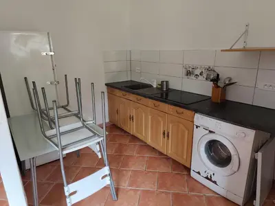 a kitchen with a washing machine and a washer at Le coin de france in LʼAiguillon