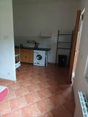 a kitchen with a washing machine and a tiled floor at Le coin de france in LʼAiguillon