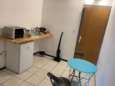 a kitchen with a counter and a blue stool at Chez Eugénia & Frédéric in Port-la-Nouvelle