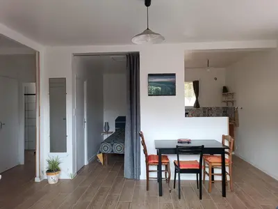 a dining room with a table and chairs and a bedroom at le studio du Chat qui Pêche in Gruissan