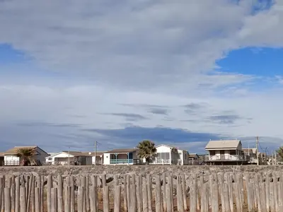 a row of houses behind a wooden fence at le studio du Chat qui Pêche in Gruissan