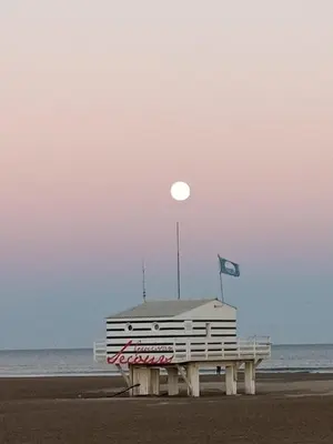a building on the beach with the moon in the sky at le studio du Chat qui Pêche in Gruissan