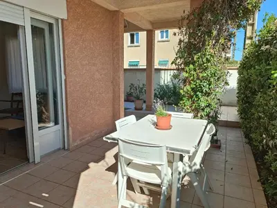 a white table and chairs on a patio at le studio du Chat qui Pêche in Gruissan