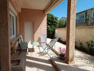 a patio with chairs and a table on a house at le studio du Chat qui Pêche in Gruissan