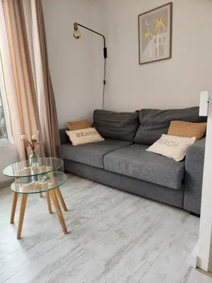 a living room with a gray couch and a glass table at Le Roof Top du Port, Nouveau, Bbq Duplex Clim Parking in Gruissan