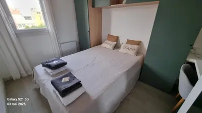 a small bedroom with a white bed with towels on it at Le Roof Top du Port, Nouveau, Bbq Duplex Clim Parking in Gruissan