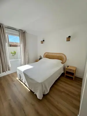 a white bedroom with a large bed and a window at Casa Dolorès parking, jardin, Gds Buffets 10 min in Narbonne