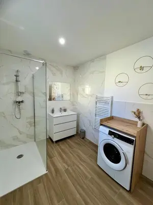 a washing machine in a bathroom with a shower at Casa Dolorès parking, jardin, Gds Buffets 10 min in Narbonne