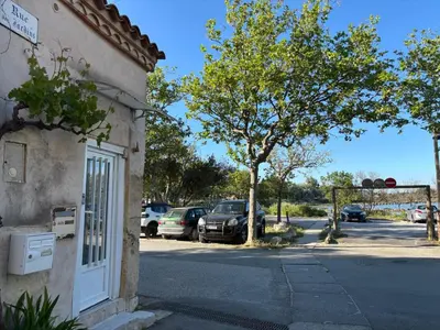a building with cars parked in a parking lot at la saline in Peyriac-de-Mer