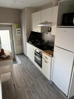 a kitchen with white cabinets and a white refrigerator at la saline in Peyriac-de-Mer