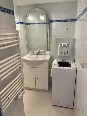 a white bathroom with a sink and a washing machine at la saline in Peyriac-de-Mer