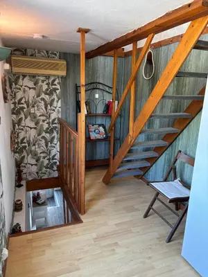 a room with a staircase with a chair and a table at la saline in Peyriac-de-Mer
