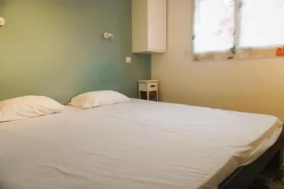 a bedroom with a bed with white sheets and a window at Le Lagon Clim Parking 4Pers in Port-la-Nouvelle