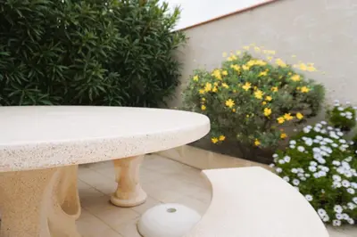 a white bench sitting on a patio with flowers at Le Lagon Clim Parking 4Pers in Port-la-Nouvelle