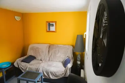 a small room with a bed in a yellow wall at Le Lagon Clim Parking 4Pers in Port-la-Nouvelle