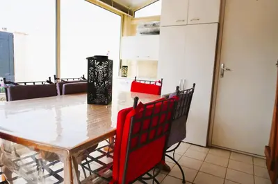 a dining room with a table and red chairs at Le Lagon Clim Parking 4Pers in Port-la-Nouvelle