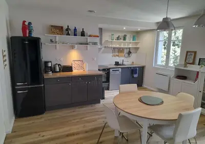 a kitchen with a wooden table and a table and chairs at Le Patio in Castelnaudary