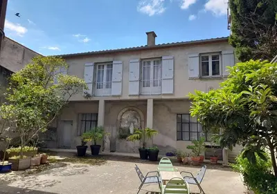 an old house with a table and chairs in front of it at Le Patio in Castelnaudary