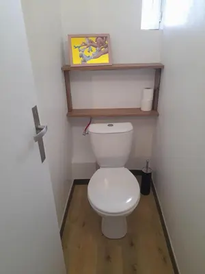 a bathroom with a white toilet in a room at Le Patio in Castelnaudary