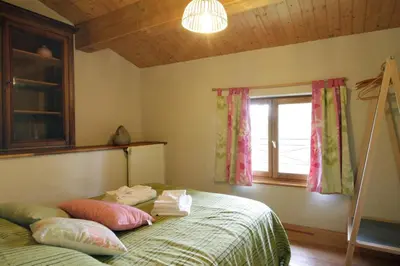 a bedroom with a bed with pillows and a window at Gite rural de Bergnes à l'ombre des grands pins in Campagne-sur-Aude