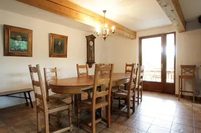 a dining room with a wooden table and chairs at Gite rural de Bergnes à l'ombre des grands pins in Campagne-sur-Aude