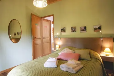a bedroom with a bed with two towels on it at Gite rural de Bergnes à l'ombre des grands pins in Campagne-sur-Aude